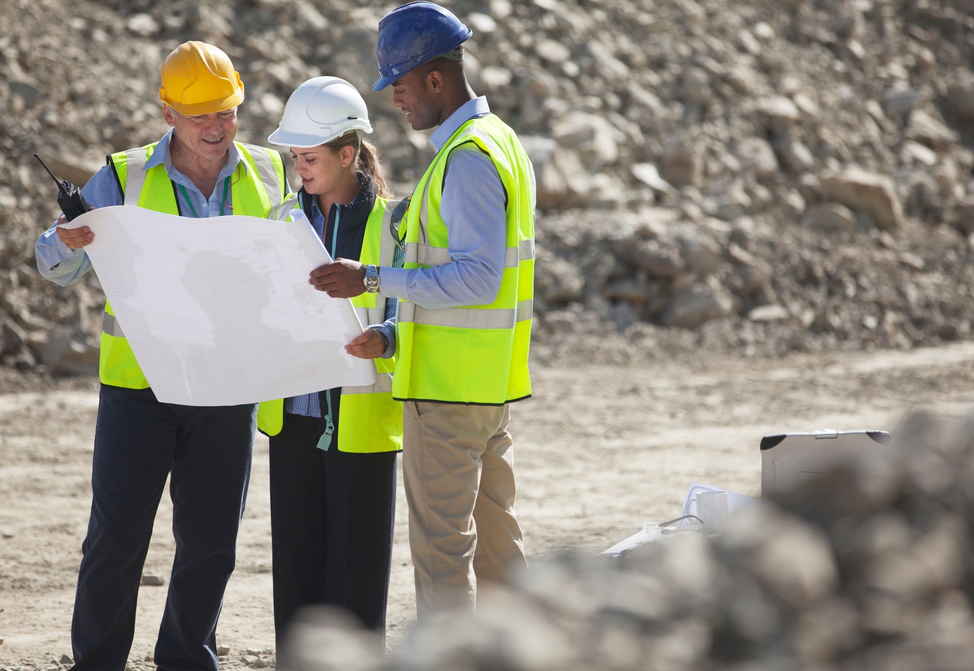 Business people reading blueprints in quarry